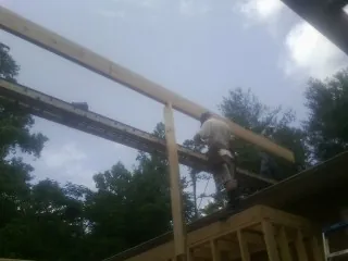 Carpenter setting a ridge beam over a new addition frame — Ice Dam Removal by Roofing Brothers in Mize