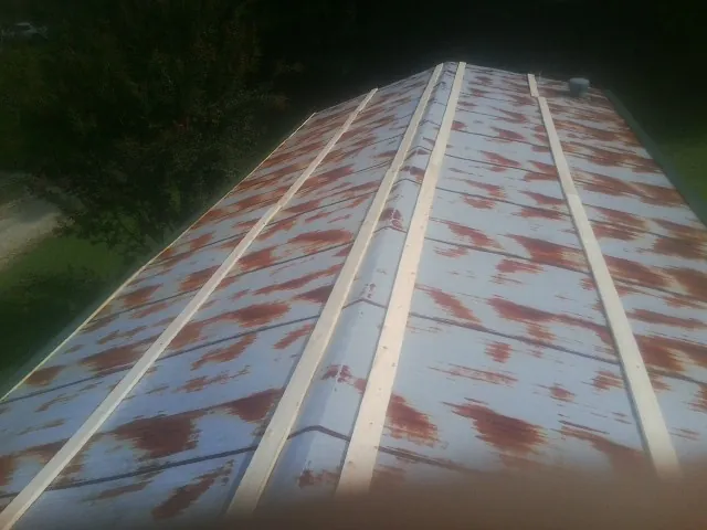 Rusted metal roof panels with new wood purlins before replacement — Storm Damage Roof Repair in Mize by Roofing Brothers