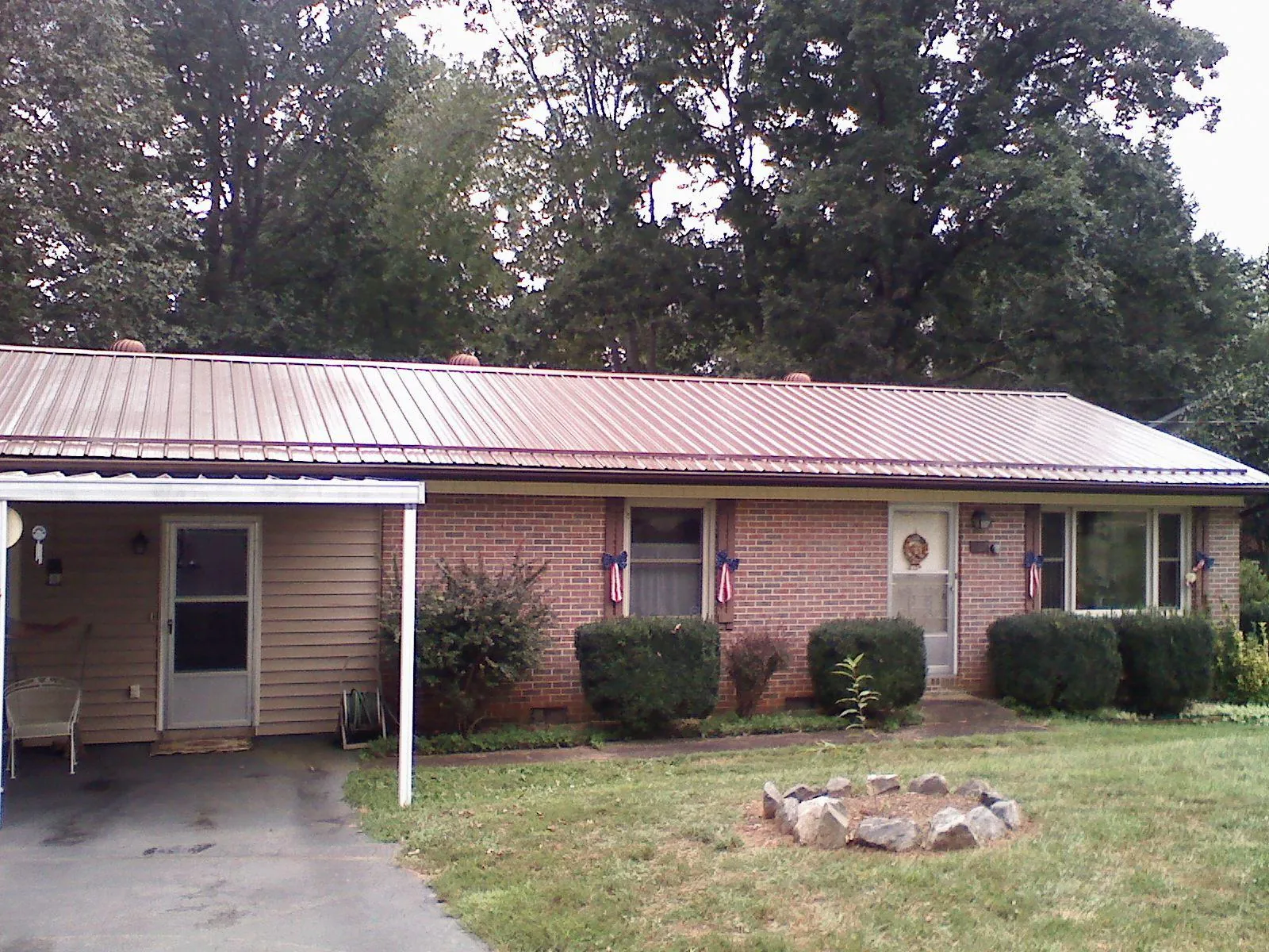 Bronze metal roof and carport on a brick ranch home — Roof Repair work by our crew in Mize